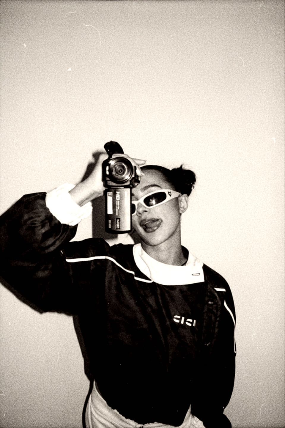 Black and white shot of CICIBI holding a camcorder